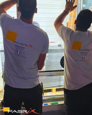Photo de deux employés de fabrix entrain de poser une fenêtre